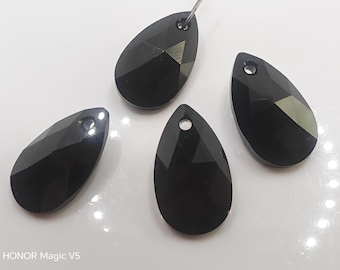 May include: Four black, teardrop-shaped faceted crystal pendants, each featuring a small circular hole at the top for suspension. The surfaces are smooth and reflective, displaying geometric facets that catch the light. The text HONOR Magic V5 is visible in the bottom left corner.