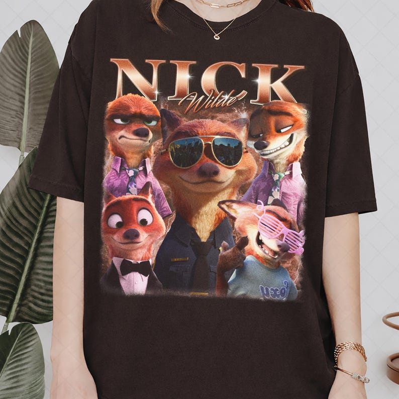May include: Dark brown t-shirt featuring a graphic of the character Nick Wilde from the animated film Zootopia. The design includes multiple images of Nick Wilde with the text "NICK Wilde" in a gold, vintage-style font.