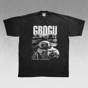 May include: Black t-shirt featuring a graphic of Grogu, also known as The Child, from The Mandalorian. The design includes the word "GROGU" in large white letters and a portrait of Grogu. The text "I would like to see the baby" is also included.