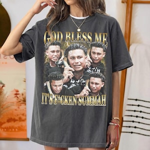 Könnte beinhalten: Dunkelgraues T-Shirt mit einer Collage von Bildern und dem goldenen Text "GOD BLESS ME" und "IT'S F*CKEN SUMMAH". Das T-Shirt hat einen Vintage-Look.