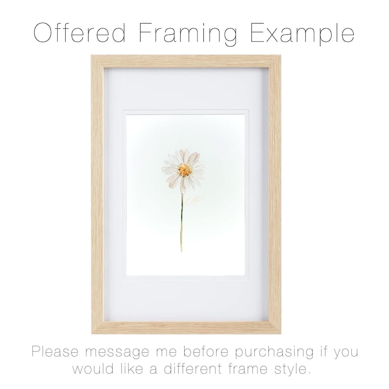 May include: A light wood frame containing a white mat and a print of a single white daisy with a yellow center. The text "Offered Framing Example" appears at the top, and "Please message me before purchasing if you would like a different frame style" at the bottom.