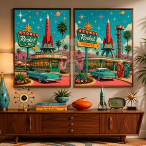May include: Two framed wall art prints depicting a mid-century modern Atomic Rocket Diner and Service station. The scenes feature teal vintage cars, red rockets, palm trees, and neon-style signage against a starry sky with mountains in the background.