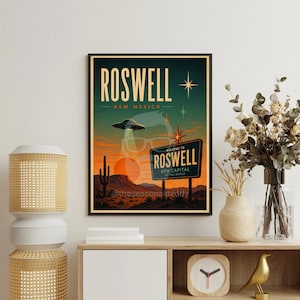 May include: A framed vintage-style poster featuring a desert landscape with a UFO and the text "Roswell New Mexico." The poster includes a sign that reads "Welcome to Roswell, UFO Capital of the World."