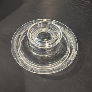 Puede incluir: Candelabro de vidrio transparente con un diseño escalonado. El candelabro tiene una base circular y un pozo central para sostener una vela. El vidrio es transparente. Adecuado para la decoración del hogar.