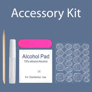 May include: An accessory kit for nail application, featuring a wooden cuticle stick, a white glue tube, a pink emery board, an alcohol pad, and a sheet of nail adhesive tabs. The text "Accessory Kit" is displayed at the top.