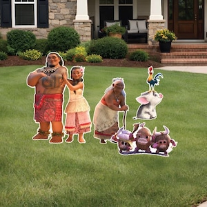 Puede incluir: Recortes de cart&oacute;n de personajes de la pel&iacute;cula animada Moana se exhiben en un c&eacute;sped verde frente a una casa. Los recortes incluyen a Moana, Maui y otros personajes. La casa tiene una fachada de piedra y un porche cubierto.