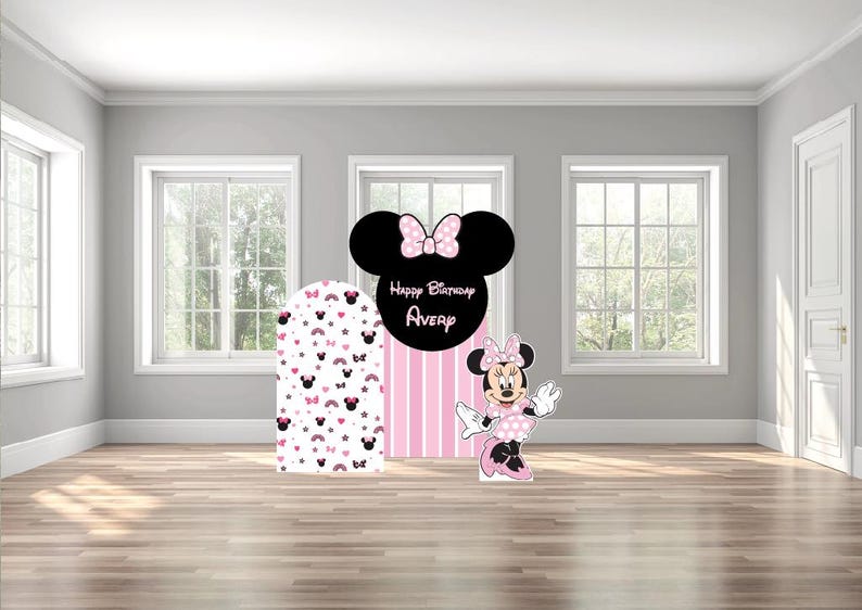 May include: A Minnie Mouse-themed birthday party decoration set. Includes a large black Minnie Mouse head with a pink bow, the text "Happy Birthday Avery", a pink and white striped backdrop, and a Minnie Mouse cutout.