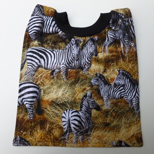 May include: A brown and black baby bib with a zebra print pattern. The bib features a black neckband and a variety of zebra stripes in different sizes and positions.