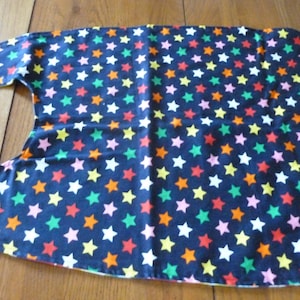 May include: A black fabric bib with a colorful star pattern. The stars are in shades of orange, yellow, green, pink, and white.