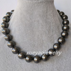 Peut inclure: Un collier de perles noires avec de grosses perles rondes. Le collier est sur un fond de velours gris. Le texte "xueyaojewelry" est visible en bas de l'image.