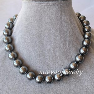 May include: A gray pearl necklace with large, round pearls. The necklace is on a gray mannequin bust.