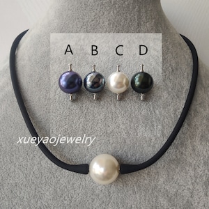 May include: A black choker necklace with a large white pearl pendant. Four smaller pearls are shown above the pendant, in colors: dark purple, dark gray, white, and dark green.