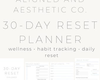 May include: A light-colored planner with the text "ALIGNED AND AESTHETIC CO." and "30-DAY RESET PLANNER." The planner includes sections for wellness, habit tracking, and daily reset. Additional text includes "CHALLANCE."