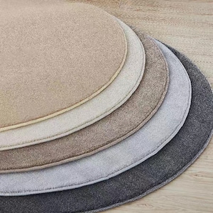Puede incluir: Una colecci&oacute;n de cinco alfombras redondas en tonos neutros variados, incluyendo beige, crema, marr&oacute;n, gris y antracita. Las alfombras est&aacute;n dispuestas en un patr&oacute;n semicircular en capas, mostrando sus diferentes colores y texturas. Las alfombras est&aacute;n hechas de un material suave y afelpado.