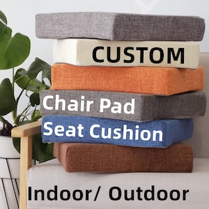 May include: A stack of custom chair pads and seat cushions in shades of grey, cream, orange, and blue. The text "CUSTOM", "Chair Pad", "Seat Cushion", and "Indoor/Outdoor" are displayed on the cushions.