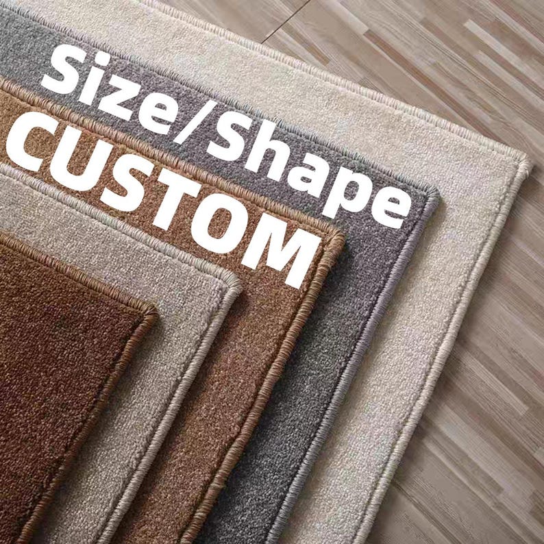 Puede incluir: Una pila de alfombras personalizadas en varios colores neutros, incluyendo marr&oacute;n, gris y beige. Las alfombras son rectangulares con una superficie texturizada y un borde contrastante. El texto "Size/Shape CUSTOM" est&aacute; superpuesto.