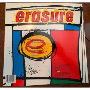 Puede incluir: Portada del &aacute;lbum de vinilo Erasure con un dise&ntilde;o audaz y colorido. La palabra "Erasure" est&aacute; en letras grandes rojas y amarillas. La car&aacute;tula del &aacute;lbum presenta una mezcla de formas geom&eacute;tricas rojas, azules y amarillas, con t&iacute;tulos de canciones.