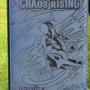 Op de afbeelding: Een blauwe kaartenbinder met de tekst "MEGA EVOLUTION CHAOS RISING" en een karakterafbeelding. De binder is gemaakt door Vault X.