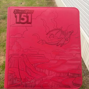 Può includere: Un raccoglitore rosso brillante per carte collezionabili con un'illustrazione a linee incise di un drago che vola sopra un paesaggio vulcanico. La copertina mostra il testo Scarlet & Violet 151 e il marchio Vault X in basso.