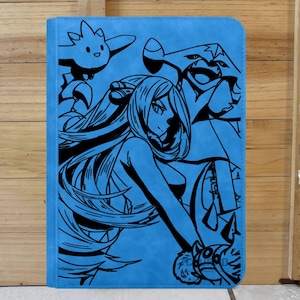 May include: A light blue tablet case featuring a black graphic design of anime characters. The artwork includes a long-haired woman and several stylized creatures. The case is rectangular and appears to be made of a textured material.