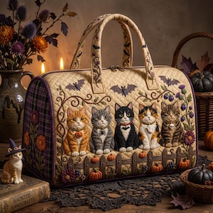 May include: A quilted beige handbag featuring an embroidered scene of five cats sitting behind a wooden fence. The cats wear small Halloween-themed collars. The bag is decorated with bats, vines, and flowers, and has two top handles with a zipper closure.