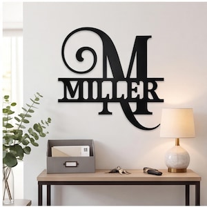 Op de afbeelding: Een zwart metalen wandbord met een grote, gestileerde hoofdletter M met een elegant krulontwerp aan de linkerkant. De naam MILLER is uitgesneden in een vetgedrukt bloklettertype over het midden van de letter als een gepersonaliseerd wandobject.