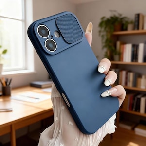 May include: A navy blue phone case with a camera cover. The case has a smooth finish with a textured camera cover. The case is designed to protect the phone's camera and body. The case is held by a person.