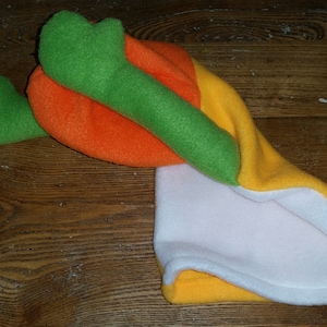 May include: A plush toy shaped like a carrot with a green top, orange middle, and yellow bottom. The toy is made of soft fabric and is suitable for children.