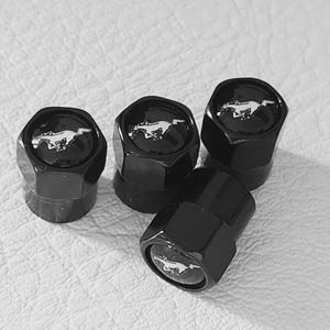 Puede incluir: Cuatro tapones de válvula de neumático negros hexagonales con un logotipo de Mustang plateado. Los tapones tienen un acabado brillante y están dispuestos sobre una superficie blanca texturizada.
