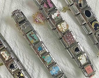 May include: Several stainless steel charm bracelets with various decorative charms. Charms include hearts, flowers, a unicorn, a lipstick, and the word "Believe". Some charms are pink, blue, and white.