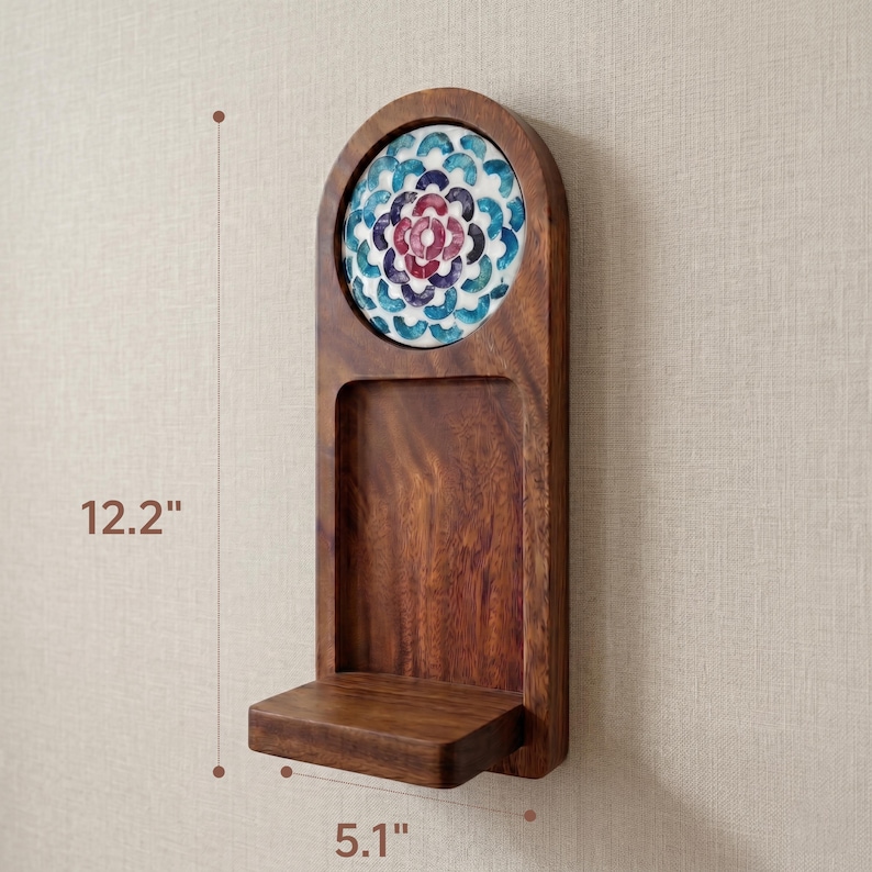 May include: A wooden wall shelf with a decorative floral tile insert. The shelf is 12.2 inches tall and 5.1 inches wide. The tile features a blue, red, and white floral pattern. The shelf has a small ledge at the bottom.