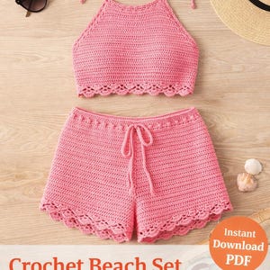 May include: A pink crochet beach set, including a halter top and shorts, with a scalloped edge design. The set is displayed with sunglasses and a straw hat on a wooden surface. The image also includes the text "Crochet Beach Set Pattern".