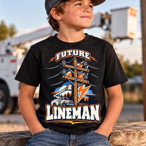 May include: A black short-sleeved t-shirt featuring a graphic print of a utility pole, a bucket truck, and a lightning bolt. The text "FUTURE LINEMAN" is printed in bold white letters above and below the central illustration in orange and blue.
