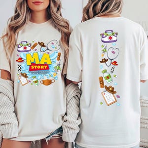 May include: An off-white t-shirt featuring a graphic print of medical supplies and cowboy-themed items. The front displays the text MA STORY TO INFINITY AND BEYOND FOR OUR PATIENTS. The back shows a vertical arrangement of the same medical icons.