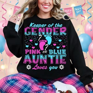 May include: Black sweatshirt with the text "Keeper of the GENDER" in pink and blue, with pink and blue footprints and hearts. The text "PINK OR BLUE AUNTIE" is below, with "Loves you" and asterisks.