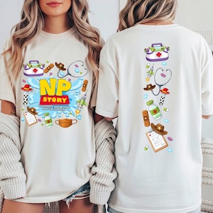 May include: An off-white t-shirt featuring a graphic print of medical and space-themed icons. The front displays the text NP STORY TO INFINITY AND BEYOND FOR OUR PATIENTS. The back shows a vertical arrangement of the same icons including a stethoscope.