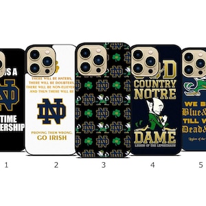 May include: A collection of five phone cases featuring the University of Notre Dame logo and imagery. Designs include the ND logo, shamrocks, and text such as "Lifetime Membership" and "Go Irish." The cases are in various colors, including black, white, and navy.