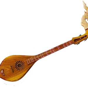 May include: A wooden Thai phin, a stringed instrument, with a teardrop-shaped body and a long neck. The body features a circular sound hole and a decorative carving at the top. The instrument is made of light brown wood.