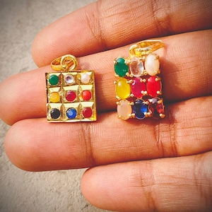 May include: Two gold pendants with colorful gemstones. One pendant is square with a grid of various colored stones. The other pendant is rectangular with a vertical arrangement of oval-shaped gemstones in different colors.