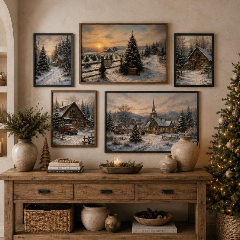May include: A gallery wall featuring five framed winter landscape prints above a wooden console table. The prints depict snowy scenes with cabins, a church, and pine trees at sunset. The console holds ceramic vases, a bowl with a candle, and books.