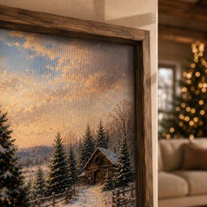 May include: A framed canvas print depicting a winter landscape with a wooden cabin nestled among snow-covered pine trees. The scene features a golden sunset sky, a light dusting of snow on the ground, and a rustic wooden fence in the foreground.