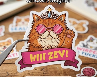 May include: A sticker or magnet featuring a cartoon cat with orange fur, pink sunglasses, and a crown. The cat is waving with a paw. A pink banner below reads "HIII ZEV!" The text "Sticker/Magnet" is above the cat.