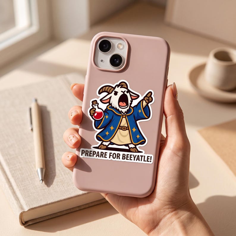 May include: A matte light pink smartphone case featuring a sticker of a cartoon goat dressed as a wizard in a blue robe with gold stars, holding a red potion bottle, with the text PREPARE FOR BEEYATLE! printed in bold black capital letters.
