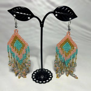 Puede incluir: Un juego de tres tazas de cerámica con un acabado mate moteado. Cada taza presenta un color diferente: azul claro, crema y gris. Las tazas tienen un diseño simple y moderno y un asa cómoda.