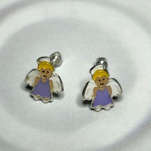 A pair of silver earrings with cartoon-like angel designs on a white background.