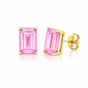 May include: A pair of stud earrings featuring emerald-cut pink gemstones set in yellow gold. One earring is shown from the front, while the other is angled to display the gold setting and the post back mechanism with a secure butterfly clutch.