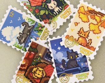 Puede incluir: Un conjunto de sellos de arte pixelado con ilustraciones de gatos. Los sellos muestran las palabras "Stardew Valley" y presentan escenas como un gato en un jardín de rosas y un gato frente a una chimenea. Los sellos tienen un valor de 32 centavos.