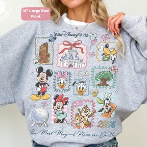 Puede incluir: Sudadera gris jaspeada con un estampado grande y colorido con personajes y lugares de Disney. El dise&ntilde;o incluye a Mickey Mouse, Minnie Mouse, Donald Duck y Chip y Chop, con el texto "Walt Disney World" y "The Most Magical Place on Earth".