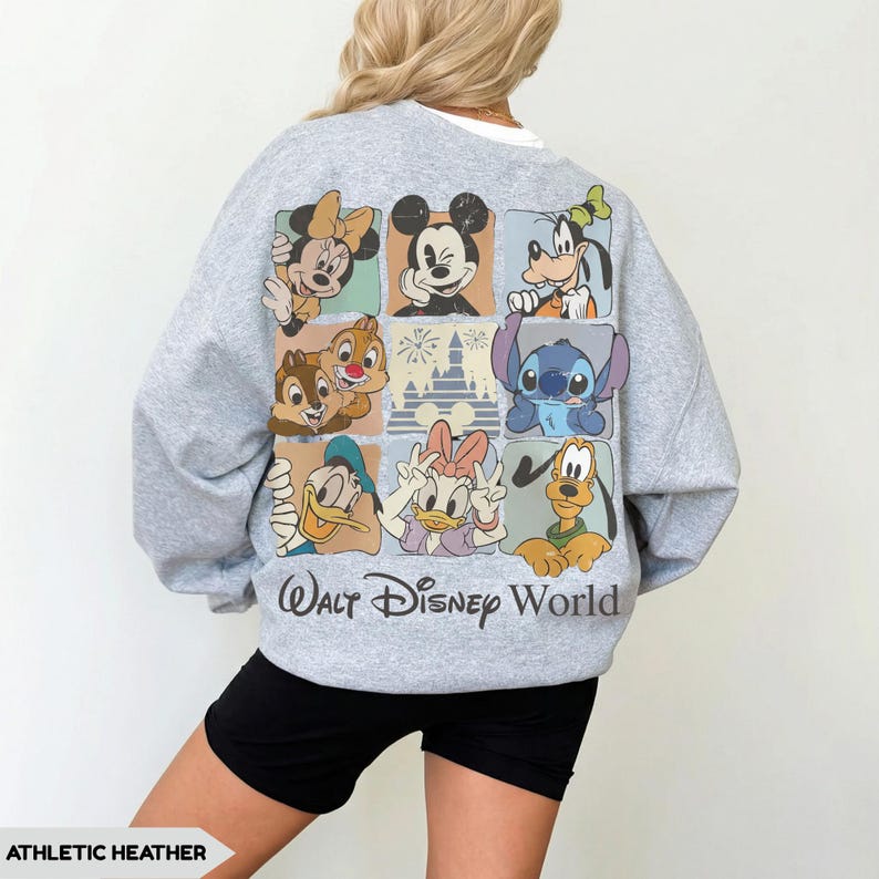 Może przedstawiać: Szara bluza sportowa z kolorową grafiką postaci Disneya, w tym Myszki Miki, Myszki Minnie, Goofy'ego i Stitcha. Tekst "Walt Disney World" jest wydrukowany poniżej. Bluza ma swobodny styl.