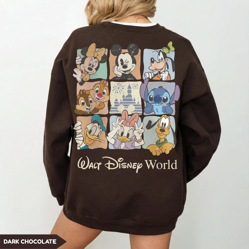 Może przedstawiać: Ciemnobrązowa bluza z nadrukiem postaci Disneya, takich jak Myszka Miki, Myszka Minnie, Goofy, Kaczor Donald, Daisy, Chip i Dale, Stitch i Pluto. Poniżej napis "Walt Disney World".